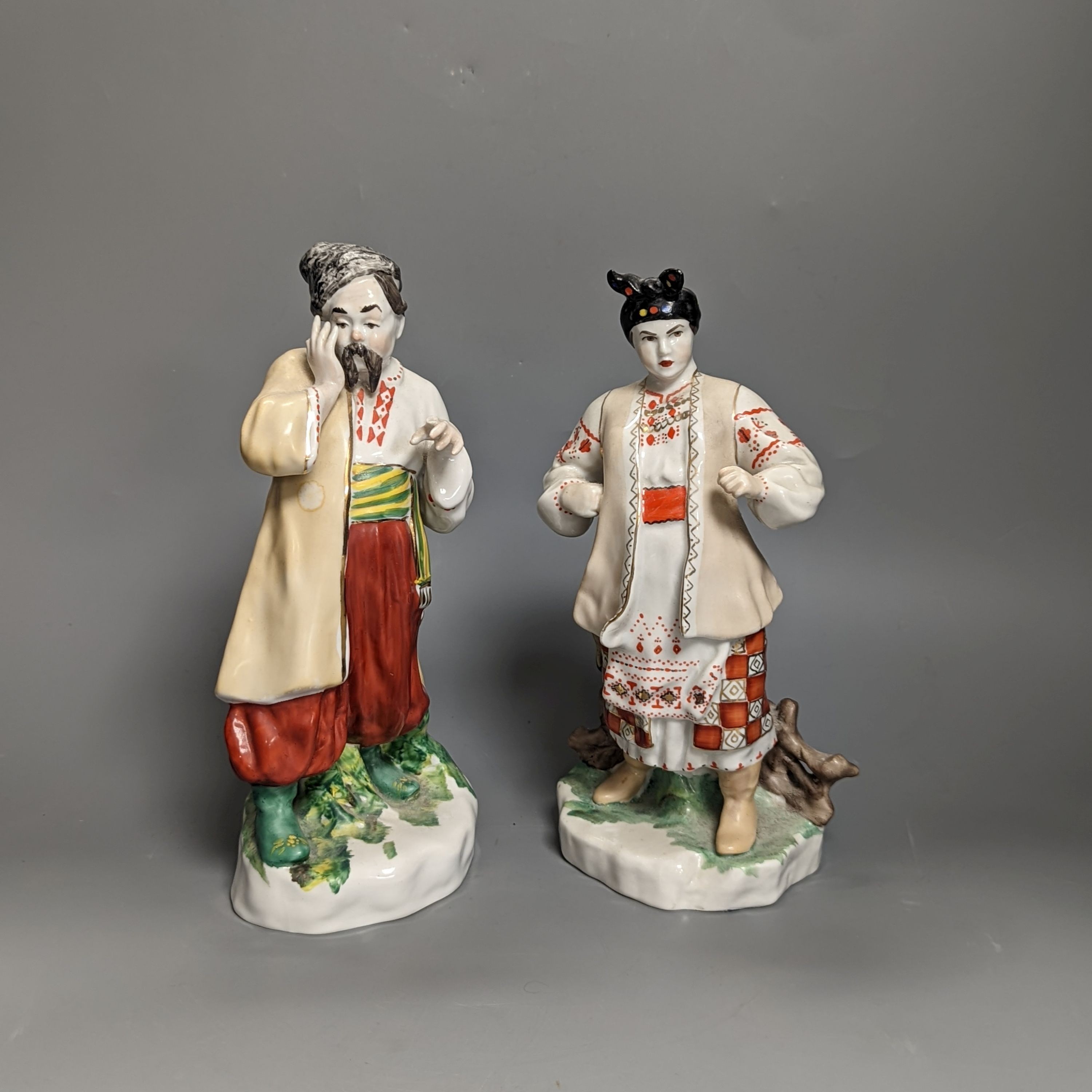 A pair of Russian porcelain figures of a Cossack and his wife 25cm